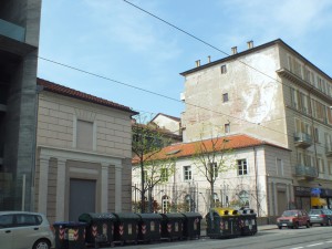 Via Nizza 52A. Sull'edificio a destra un 'graffito' dell'artista portoghese Vhils realizzato nell'ambito del progetto NizzArt. Fotografia di Paola Boccalatte, 2014. © MuseoTorino