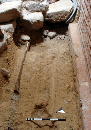 Il tratto di tubo in piombo (fistula) rinvenuto sotto il basolato del fornice settentrionale, © Soprintendenza per i Beni Archeologici del Piemonte e del Museo Antichità Egizie.