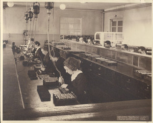 Operaie e operai al lavoro al banco per il montaggio del microtelefono presso l’Officina Riparazioni di Torino, 1938. ©Archivio Storico Telecom Italia.